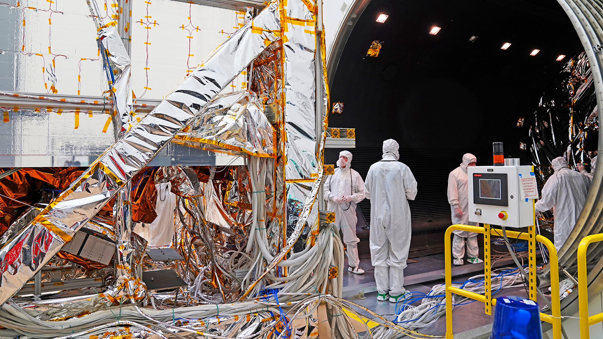 technicians dressed in bynnysuits building a satellite in cleanroom