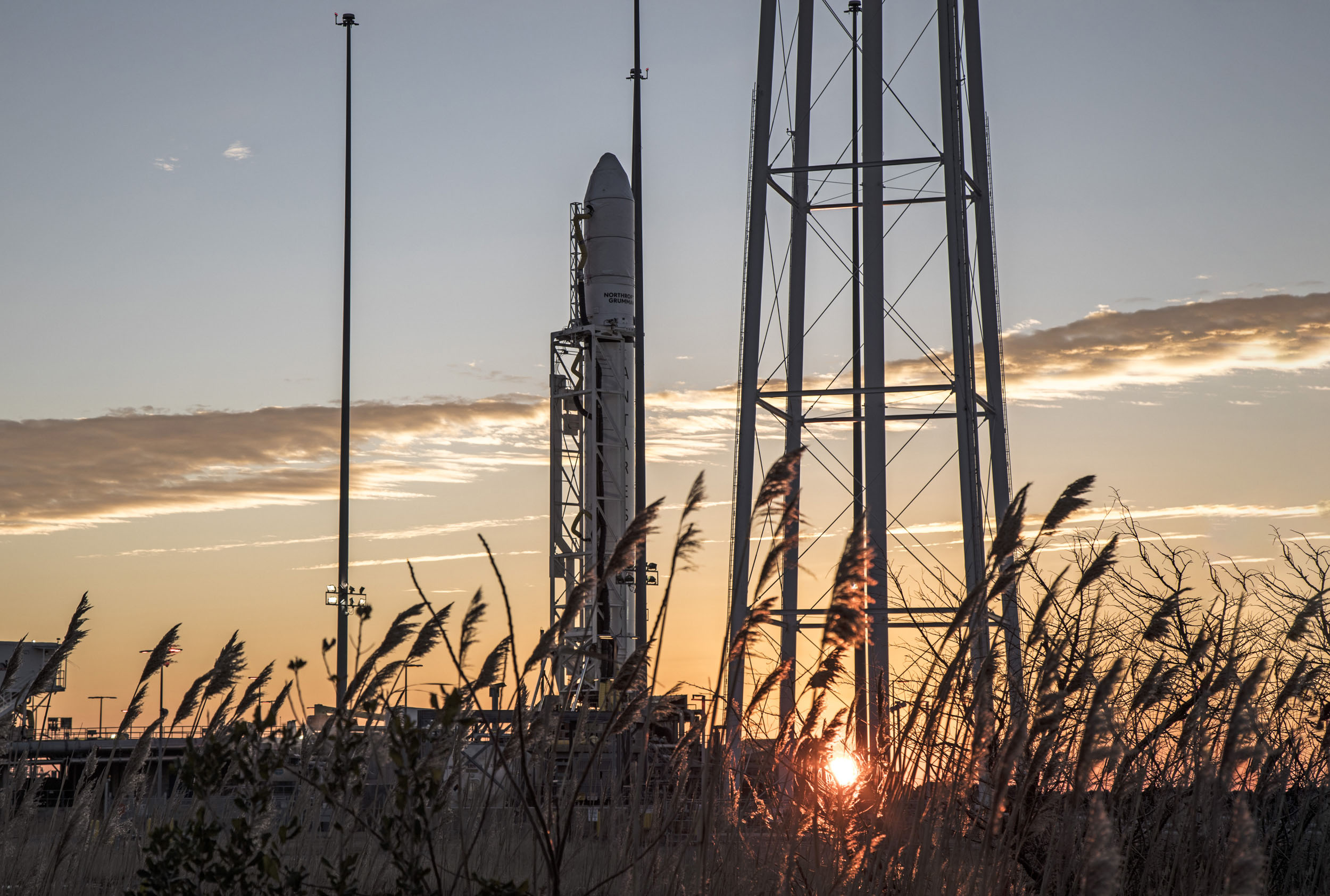 A rocket on launch pad in front of a morning sunrise