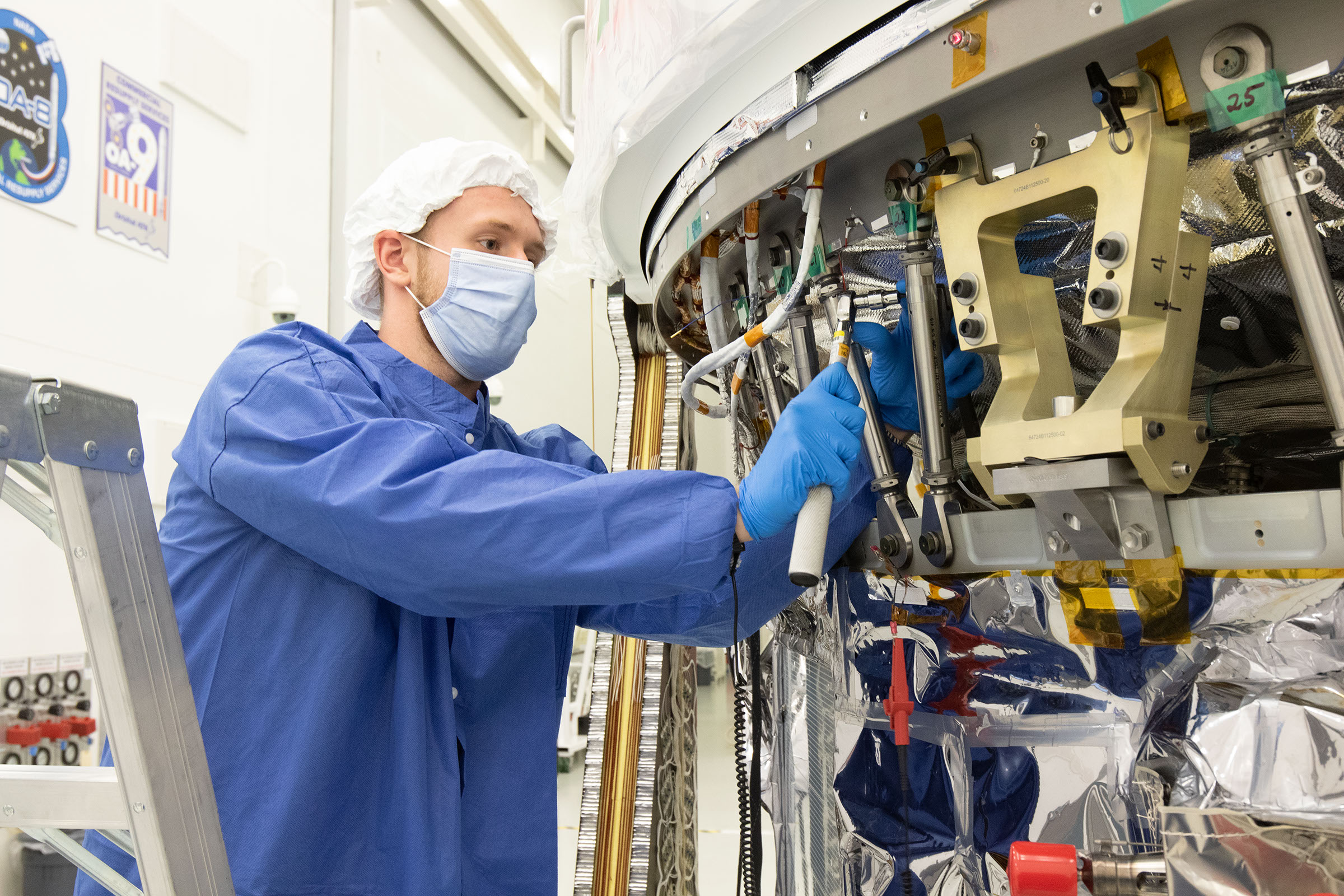 White male engineer works on the Cygnus spacecraft in assembly facility in Wallops Island, VA
